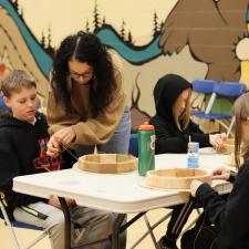 Indigenous Support Worker supporting students with drum making